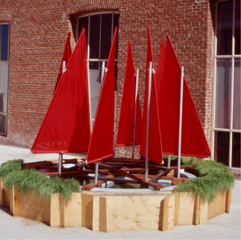 circular pool topped with floating ring of 8 red sails that spin in the wind