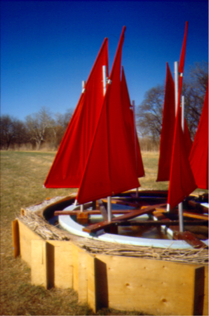 Side detail: troughs filled with dry branches with circle of sails floating in the pool.