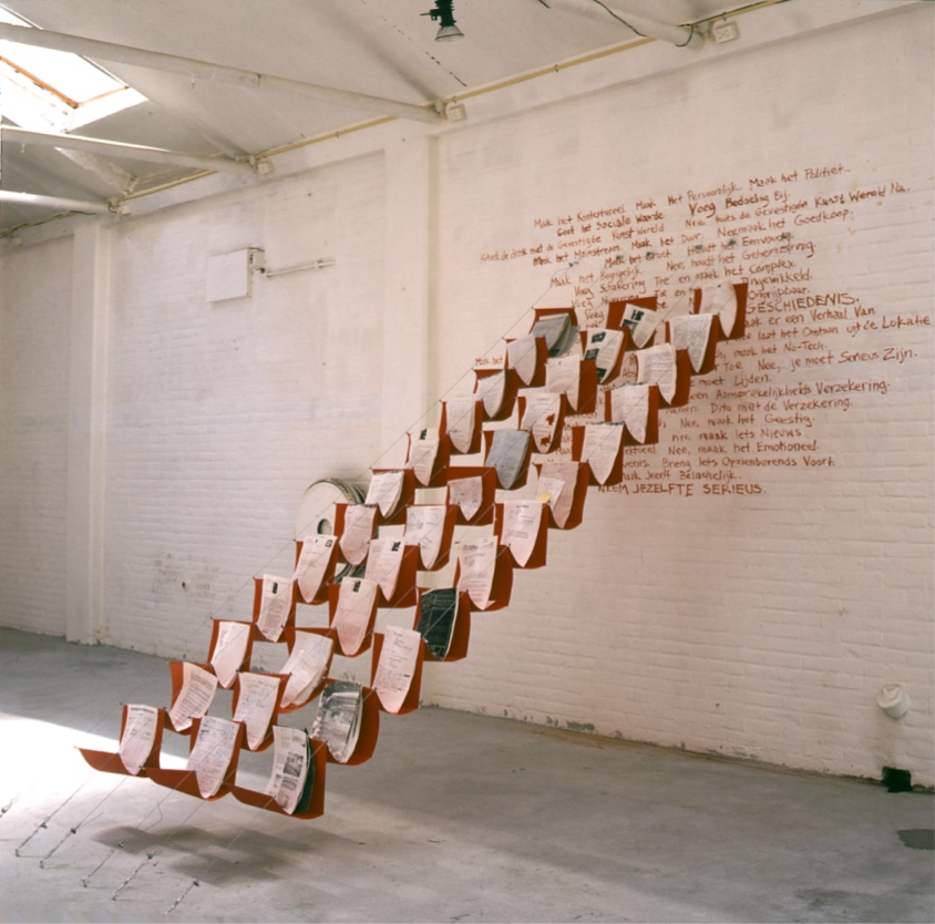 Twelve rows of 3 hanging file folders descend diagonally from the wall with cables.