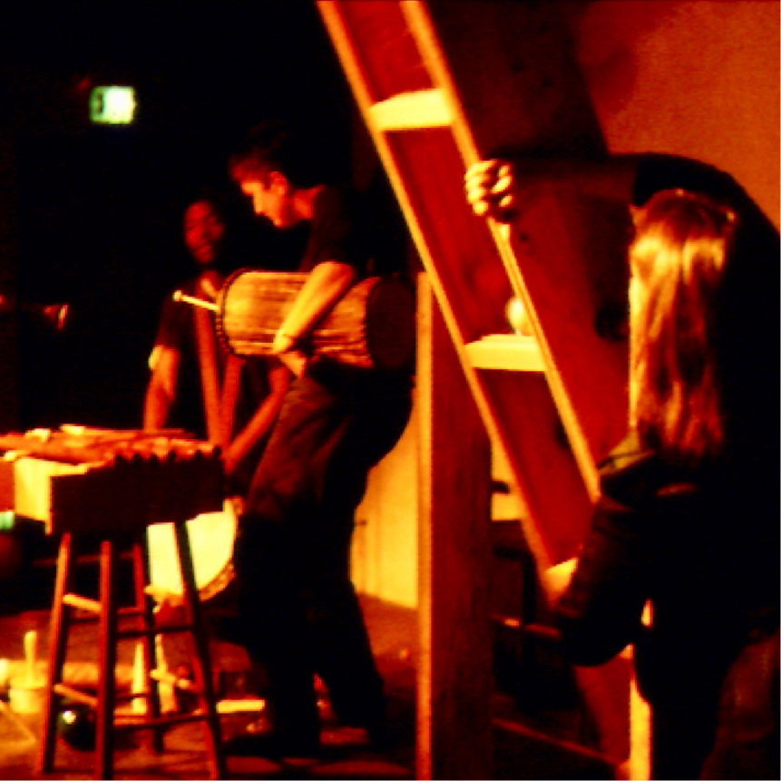 Judith plays an 8 ft palo de lluvia filled with billiard balls, 2 others perform in background.