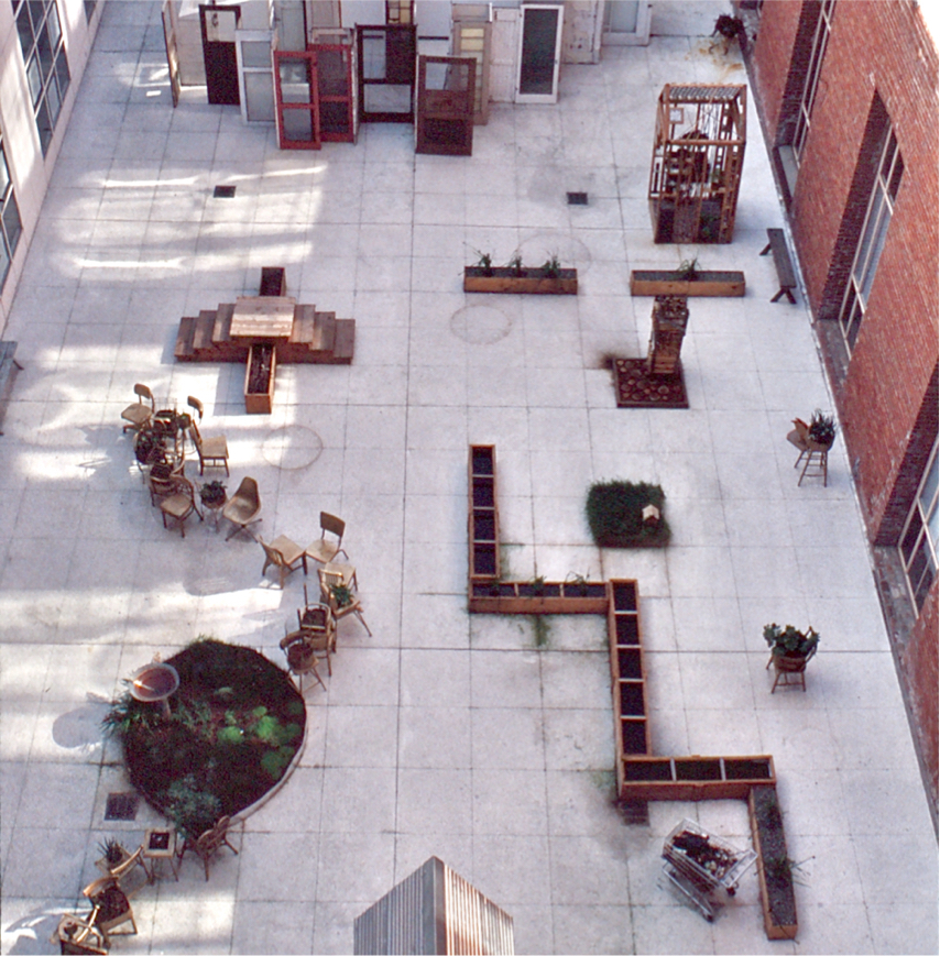 Aerial view: zig zag troughs, round garden bed, snaking chairs, and wall of doors at the back